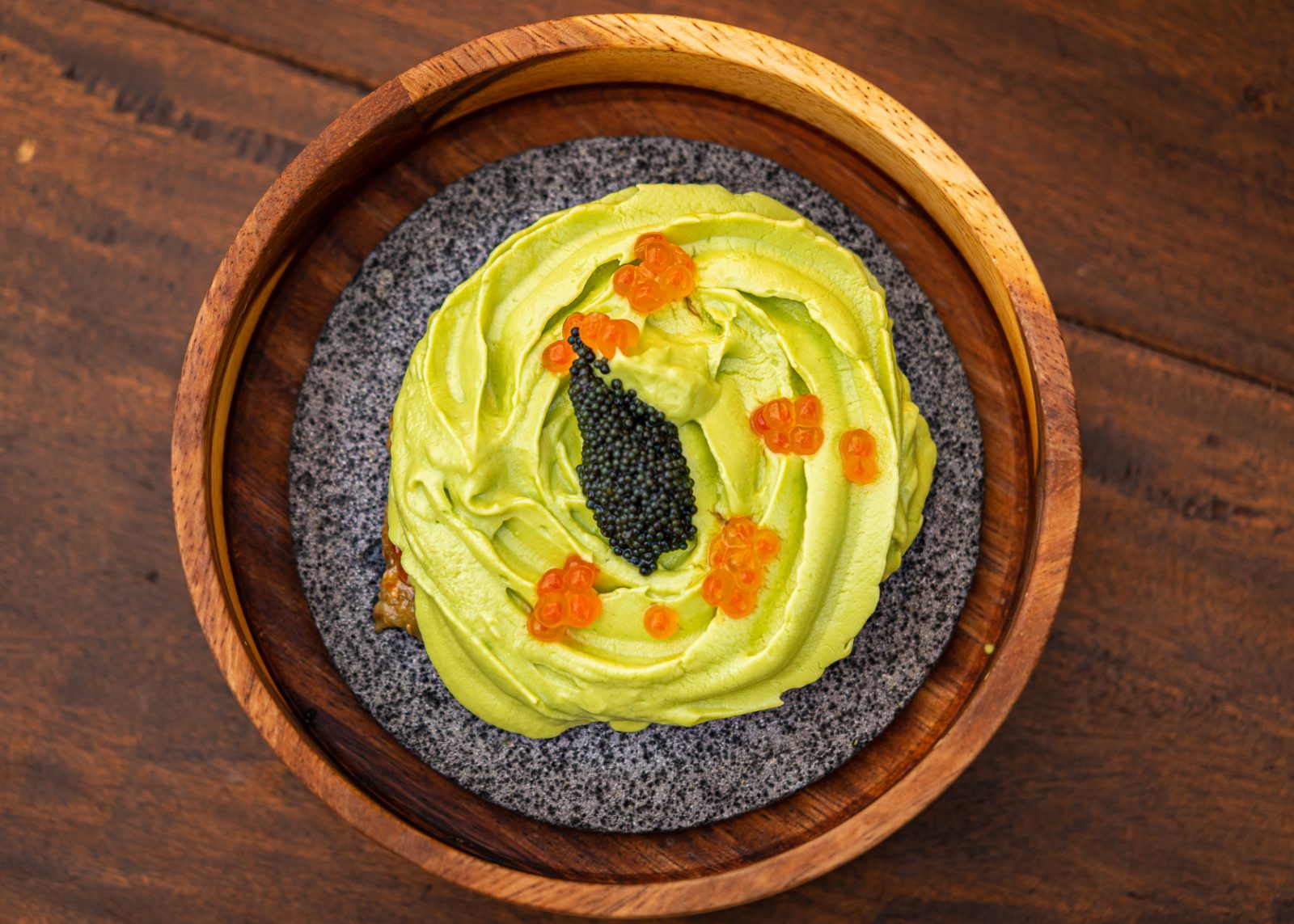 Avocado and caviar on a lava-stone dish